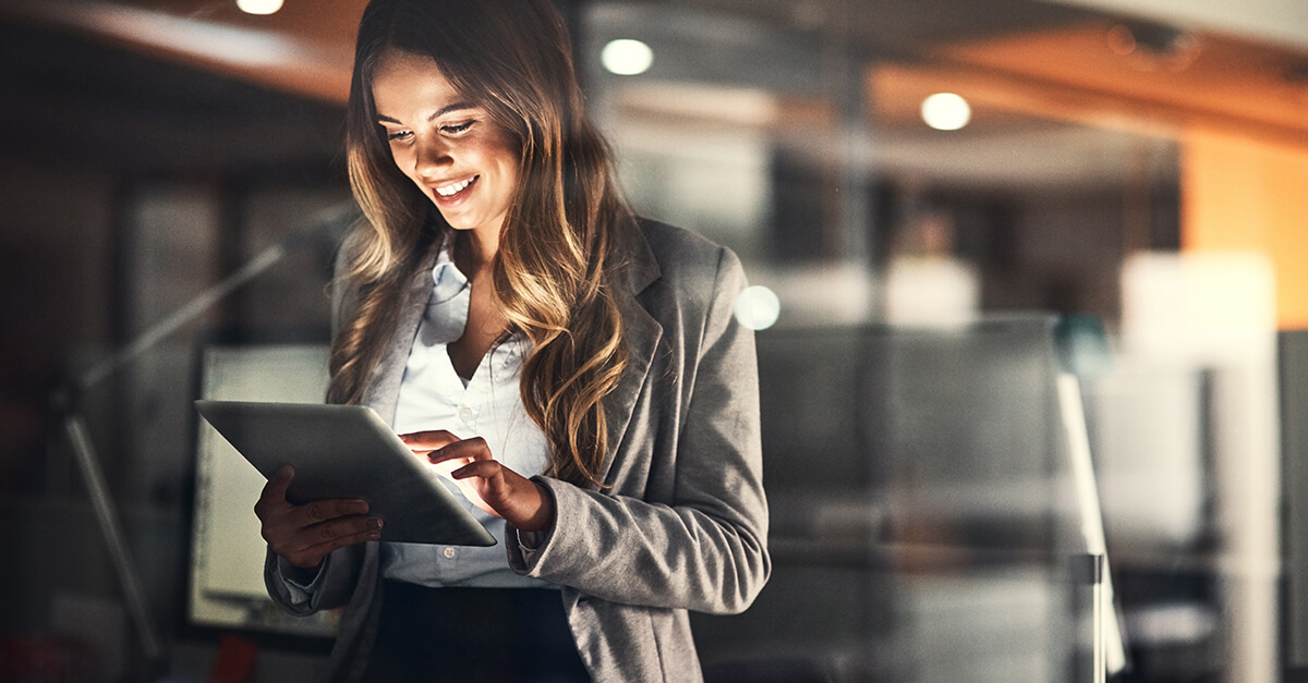 Mulher usando tablet no trabalho em alusão às práticas de transformação digital