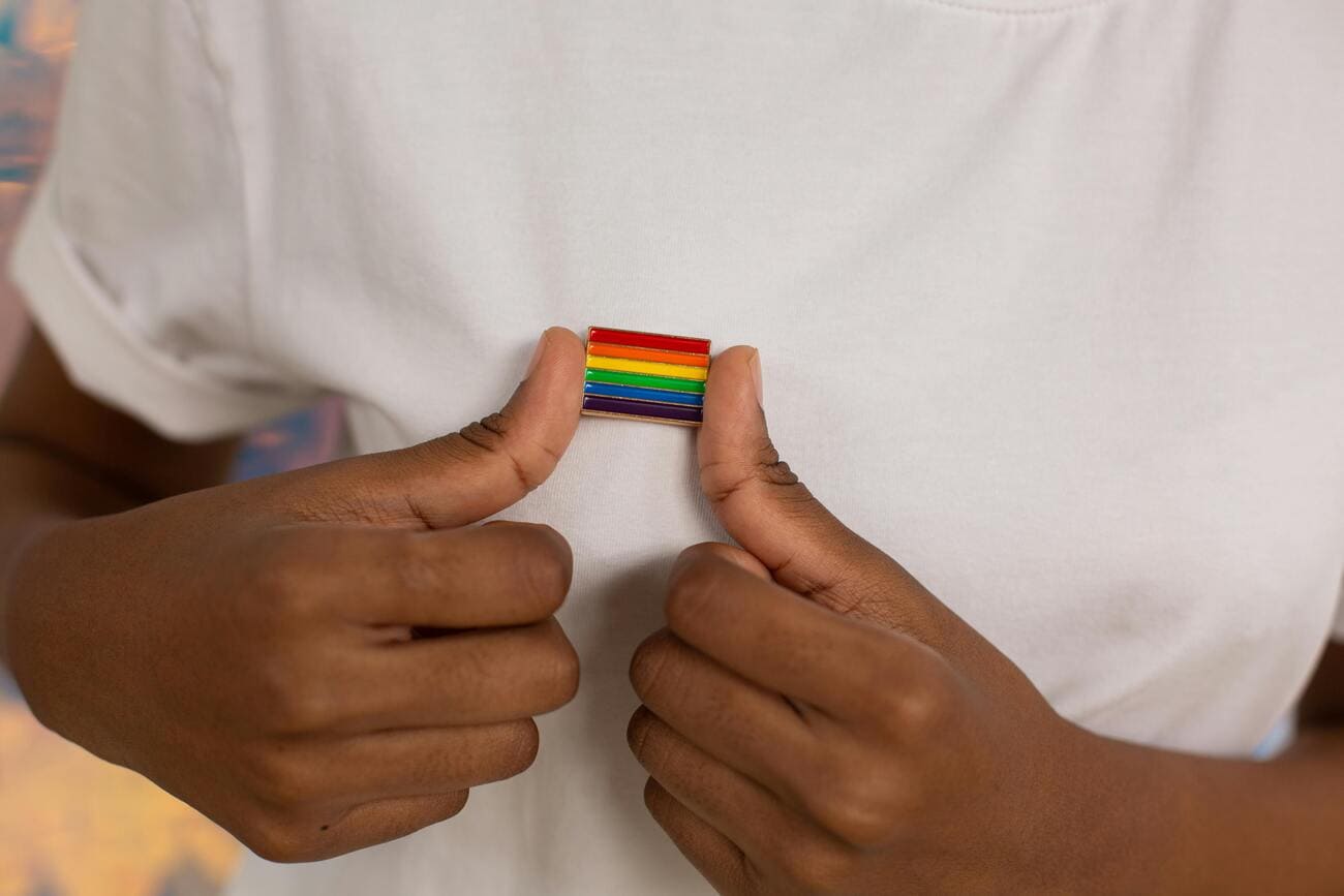 Pin com a bandeira que representa o movimento LGBTQIAPN+ em alusão ao combate à LGBTfobia no ambiente de trabalho.